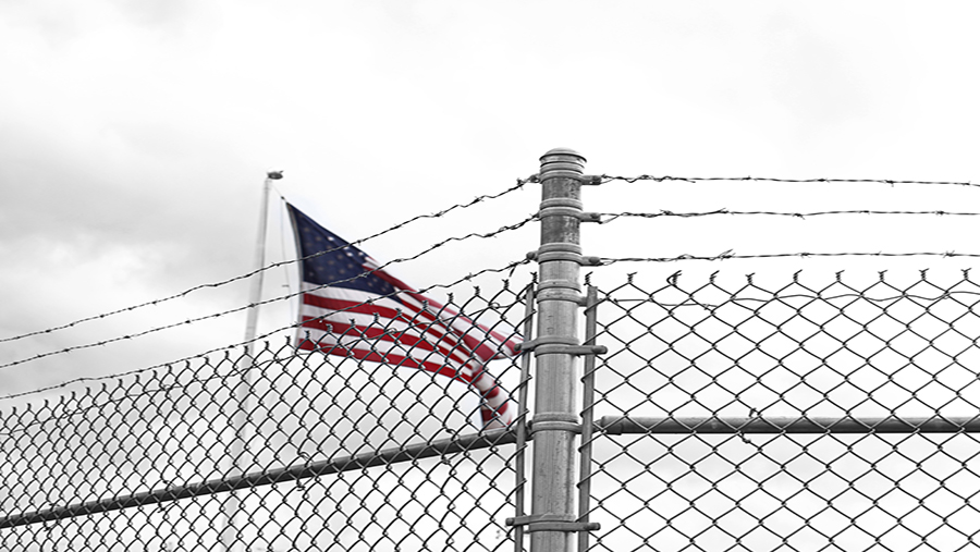 American flag behind barbed wire fence