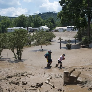 People trudge through the mud left over from the flooding of the Elk River along State Route 119, on June 25, 2016 in Falling Rock, West Virginia. 