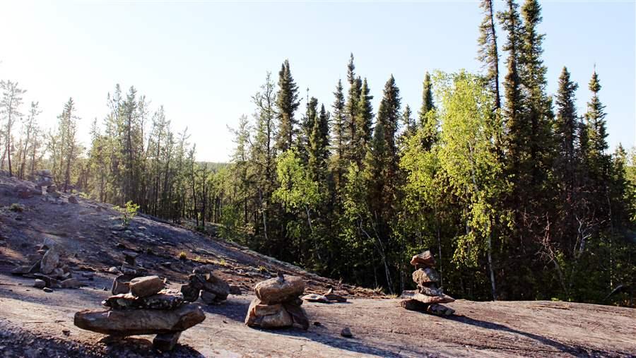 Inukshuk, or manmade stone landmarks, line the Cameron Falls Trail in the boreal forest region of Canada's Northwest Territories.
