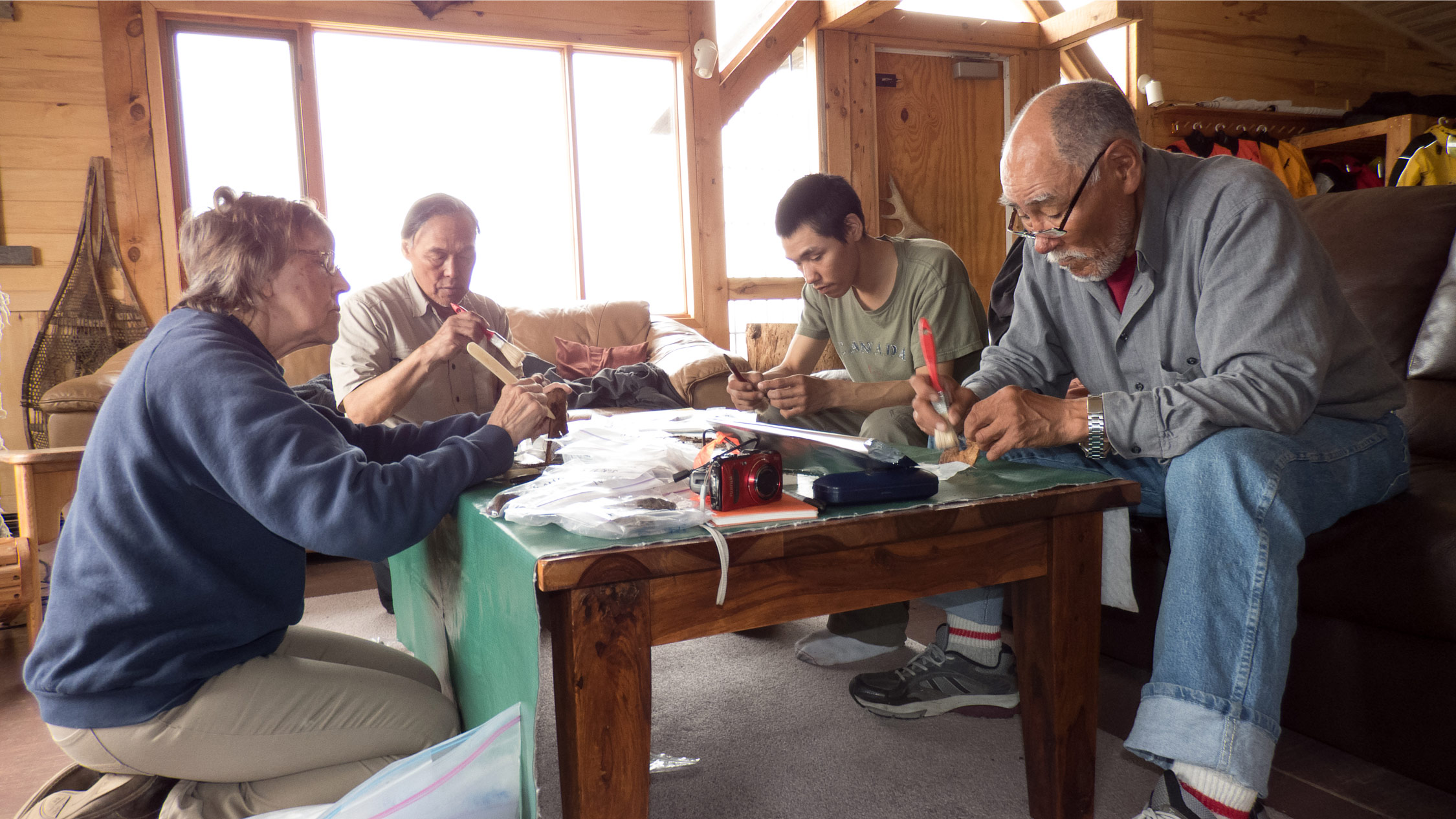 Preparing artifacts for carbon dating and other analyses at the lodge, from left: Virginia Petch, Luke Suluk, David Tassiuk, and Peter Alareak.