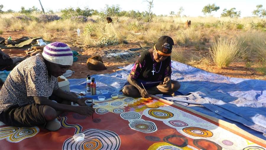 Pintupi Traditional Indigenous Owners painstakingly create a group painting to celebrate the new IPA.