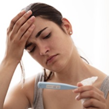 Photo of young woman holding thermometer