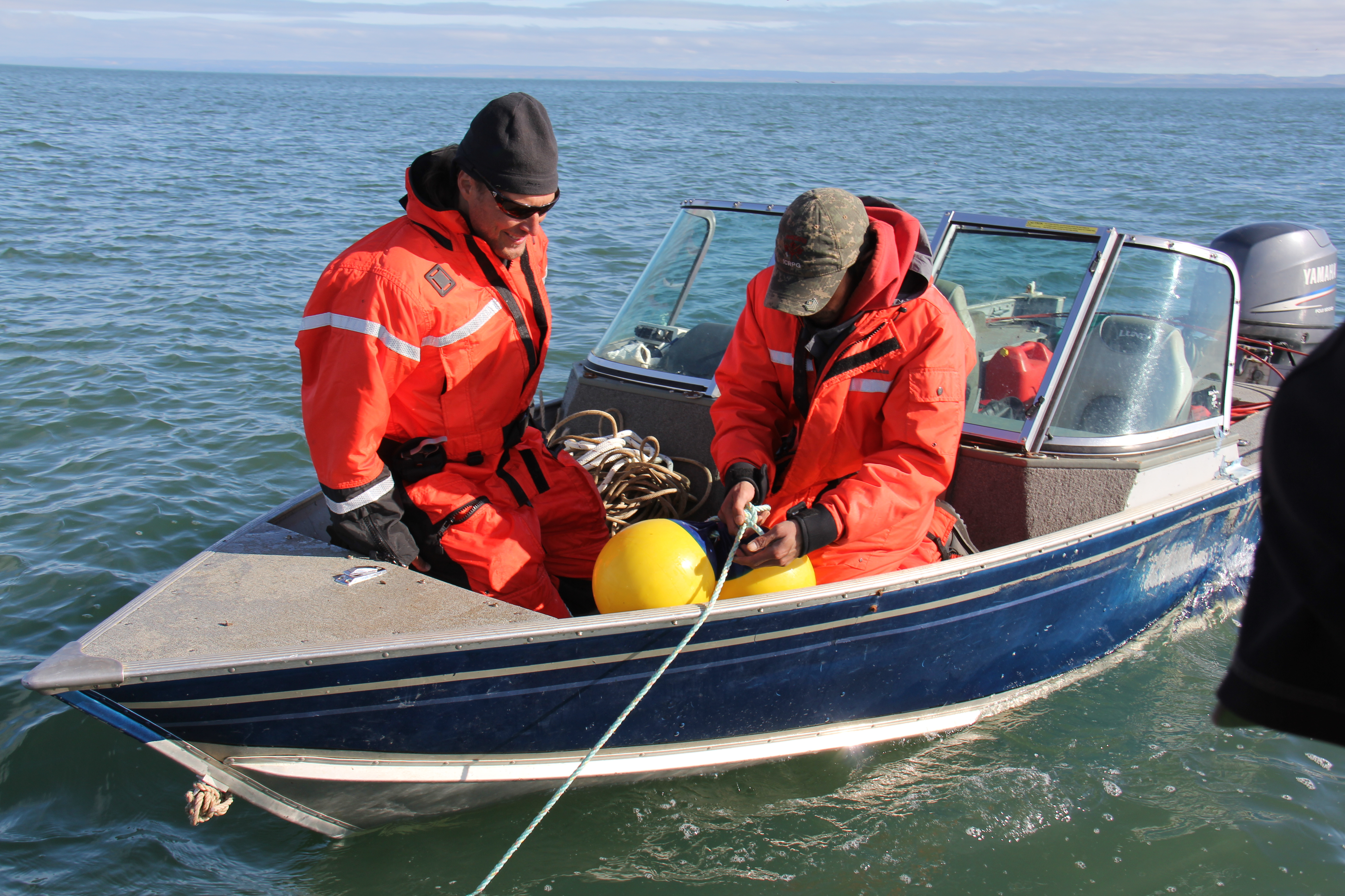 Technicians prepare buoys that will help them locate and retrieve the hydrophone in a few months.