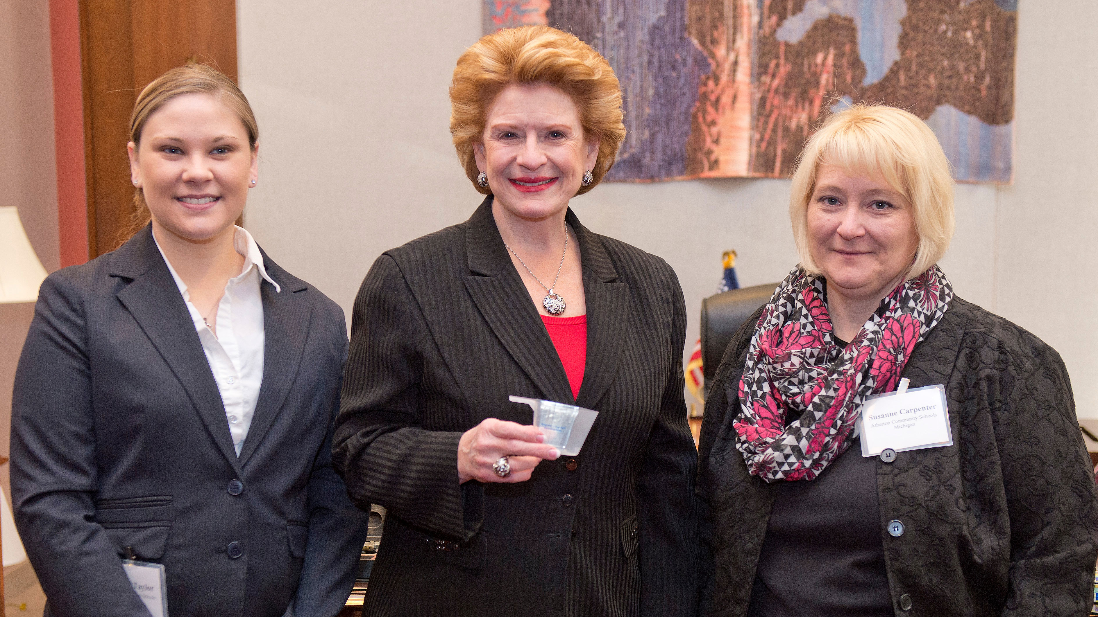 Food service director Bethany Taylor (left) and principal Susanne Carpenter (right), representing Atherton Community Schools in Michigan, show Senator Debbie Stabenow (D-MI) the half-cup portion that students must take of fruits or vegetables with every lunch. A recent survey found that 91 percent of parents nationwide support requiring schools to include a serving of fruits or vegetables with every meal.