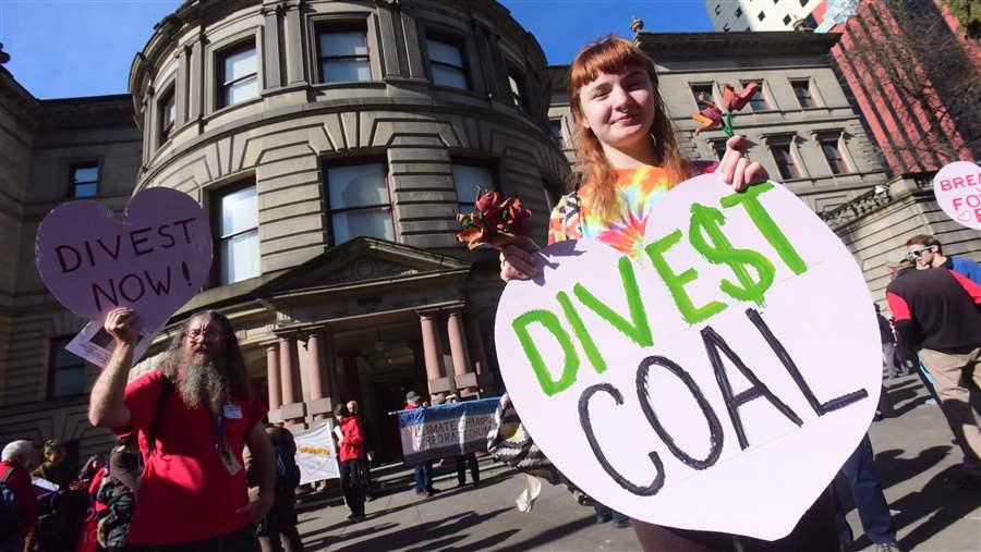 Activists demonstrate outside City Hall in Portland, Oregon, urging the mayor to divest the city’s holdings in fossil fuel companies. Several states are considering bills that would have state pension systems divest their coal and oil stocks. (AP)