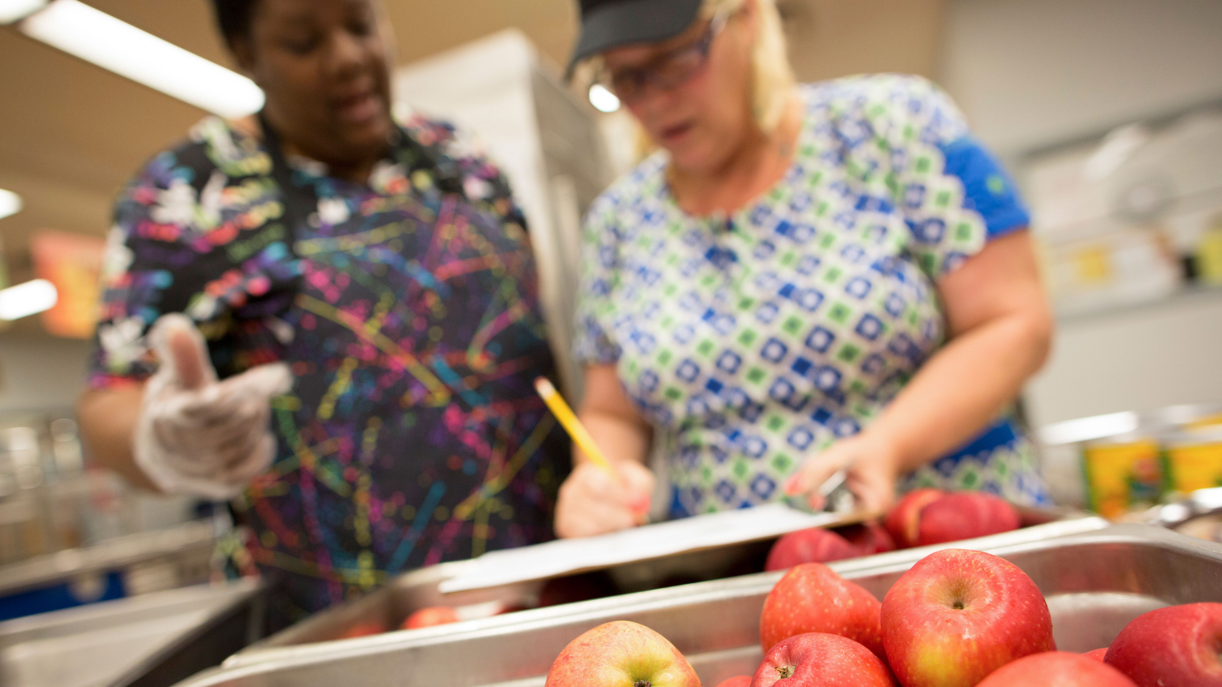 Cafeteria staff prepare school lunches for students.