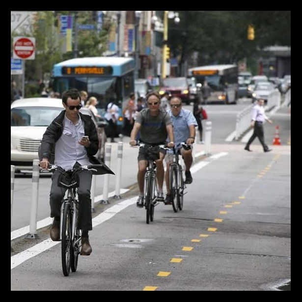 A bicyclist looks at an electronic device A bicyclist looks at an electronic device
