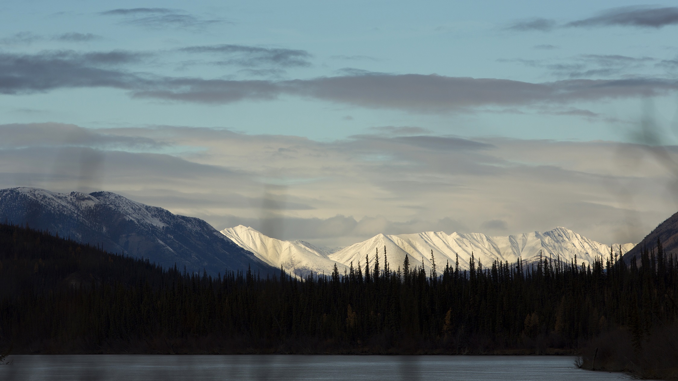 The Mackenzie Mountains loom above trees lining the 335-mile-long South Nahanni River