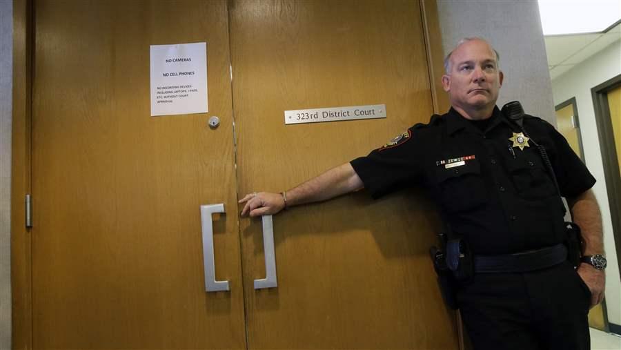 A guard stands outside a juvenile courtroom