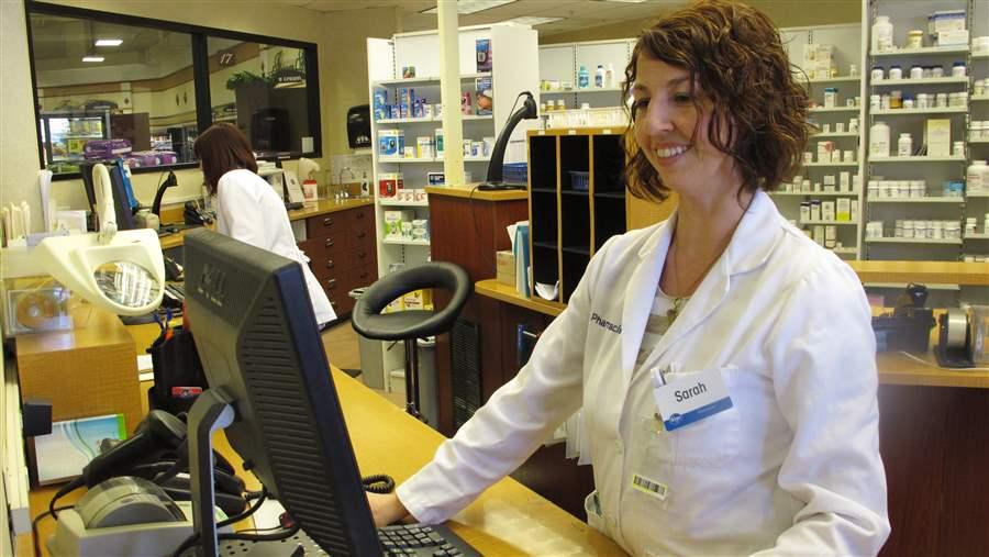 Pharmacist Sarah Burke checks a prescription drug database