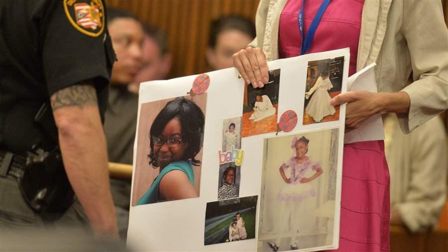 court worker holds a board of photos
