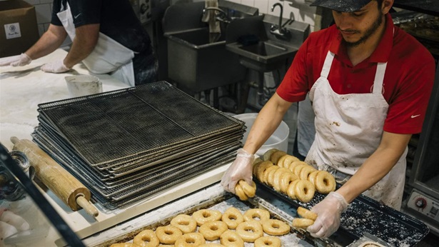 Baker making doughnuts