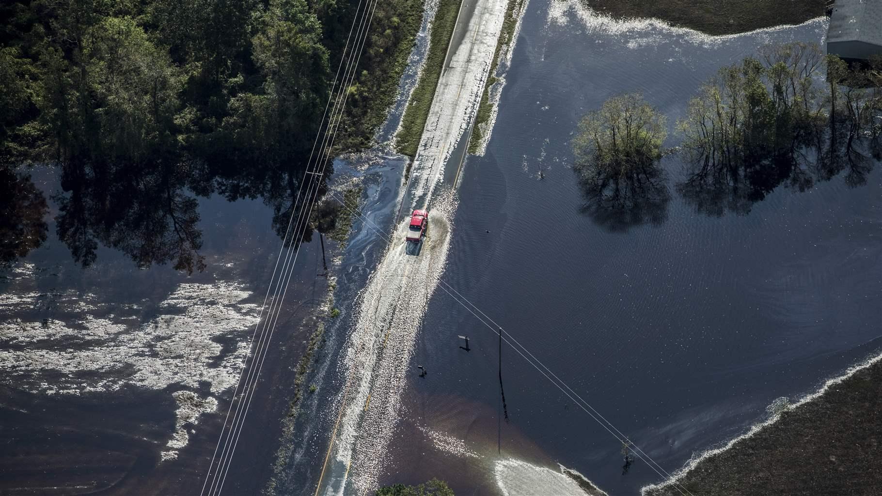 truck drives through floodwater