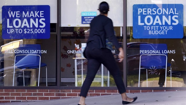 A woman walks past a personal finance loan office