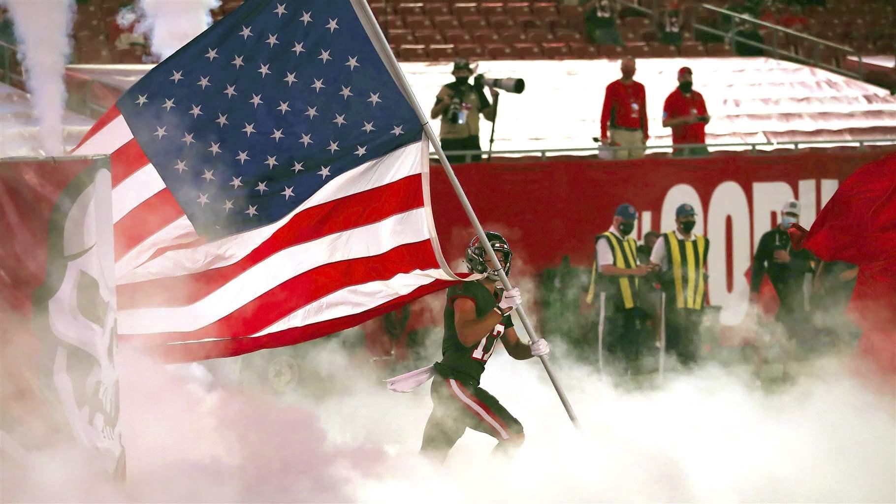 NFL player carrying American flag
