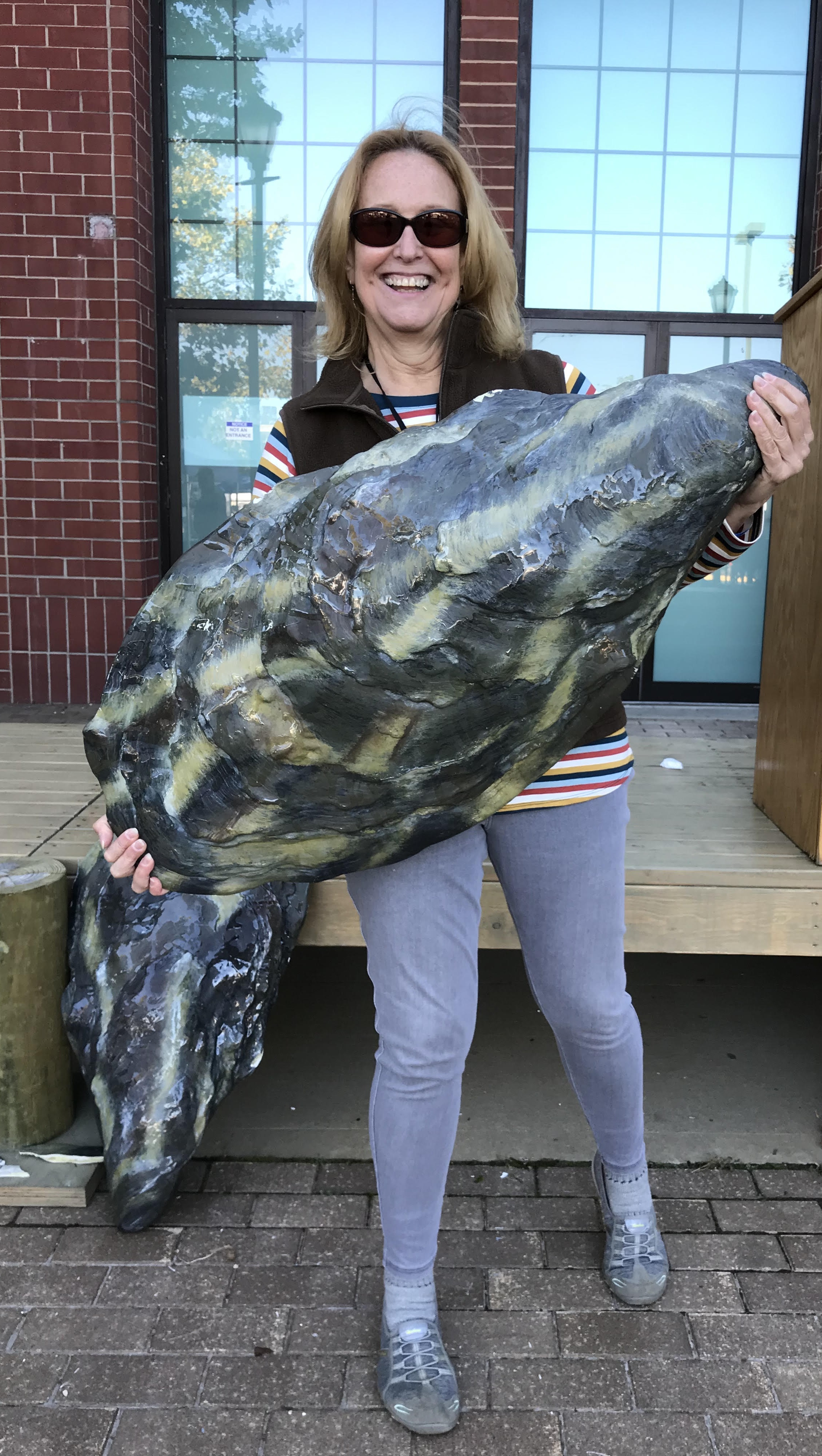 Maureen Dunn, a water quality scientist with Seatuck Environmental Association on Long Island, holds a prop of an enlarged oyster shell at the Blue Point Brewery’s Oyster Ball.