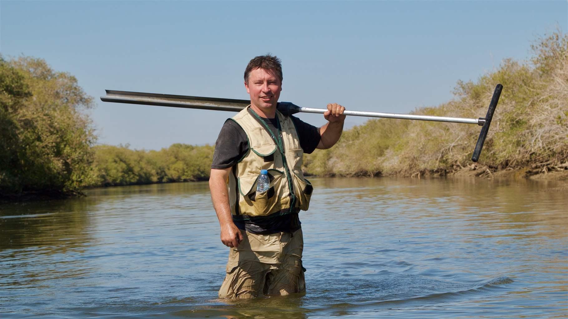 Steve Crooks holding equipment in water in Khor Kalba