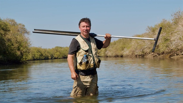 Steve Crooks holding equipment in water in Khor Kalba