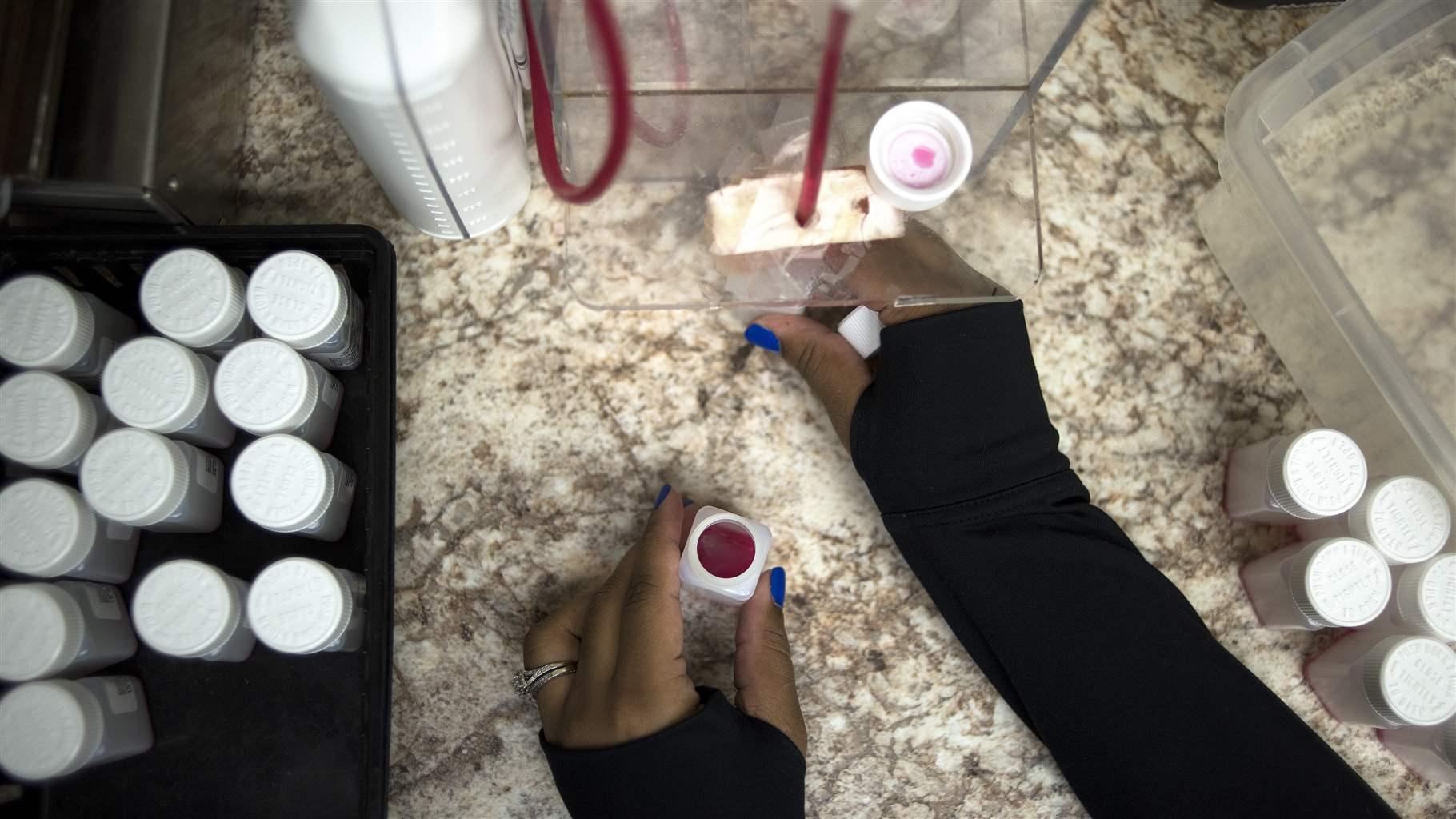 Nurse filling medication bottles