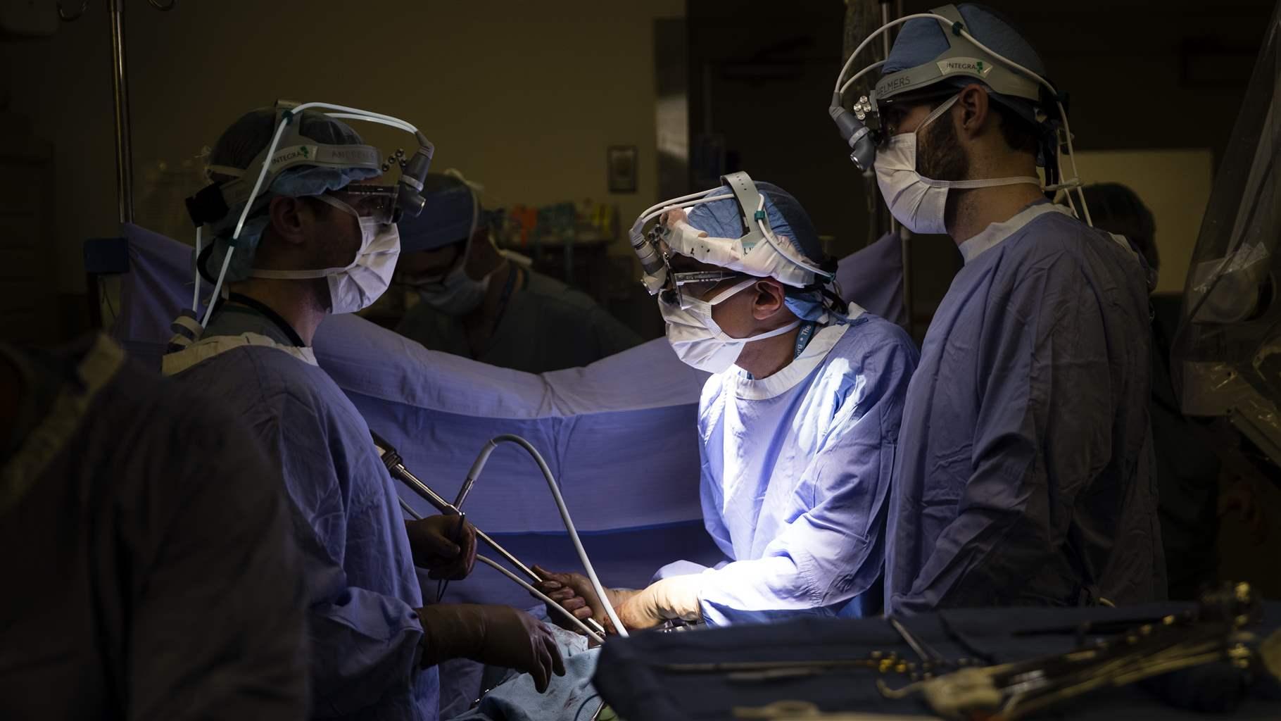 CANCER DEATHS HEALTH INSURANCE In this Tuesday, Jan. 23, 2018 file photo, a doctor, center, directs a special camera to look at a patient's tumor at a hospital in Philadelphia. According to research released on Wednesday, May 13, 2020, cancer deaths have dropped more in states that expanded Medicaid coverage under the Affordable Care Act than in states that did not.