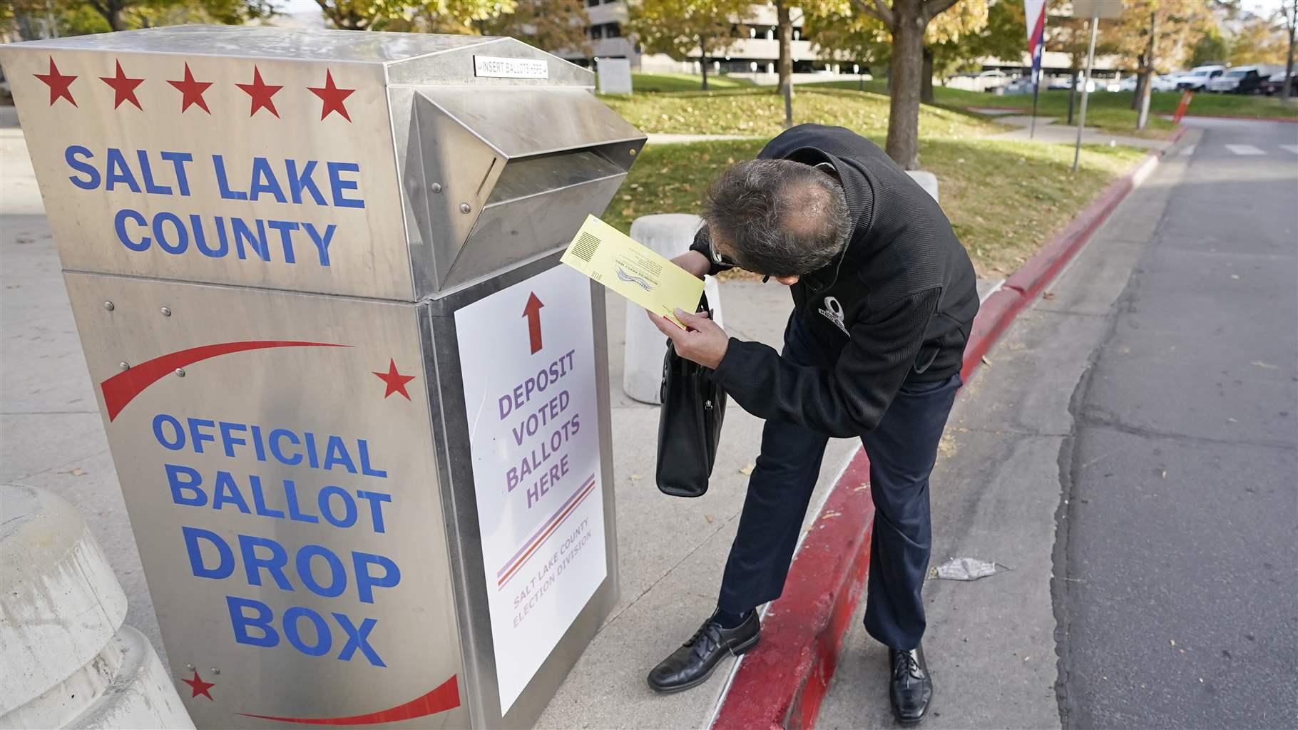 Phil Martinez inserts his ballot into an official ballot drop box Tuesday, Oct. 20, 2020, in Salt Lake City.