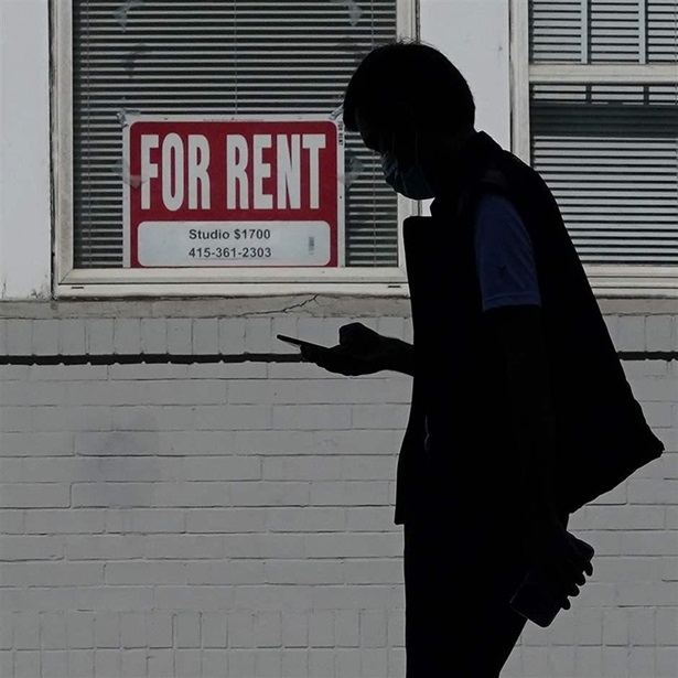 man walks past a For Rent sign 