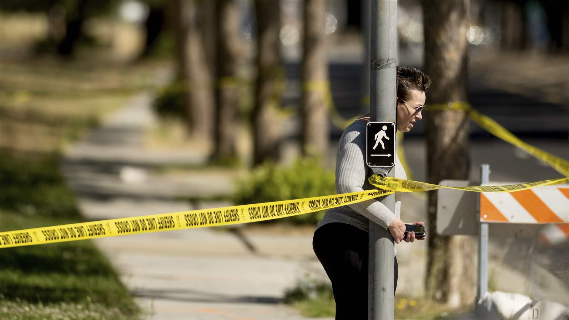 A woman leaves the scene of a shooting at a Santa Clara Valley Transportation Authority (VTA) facility on Wednesday, May 26, 2021, in San Jose, Calif. Santa Clara County sheriff's spokesman said the rail yard shooting left multiple people, including the shooter, dead.