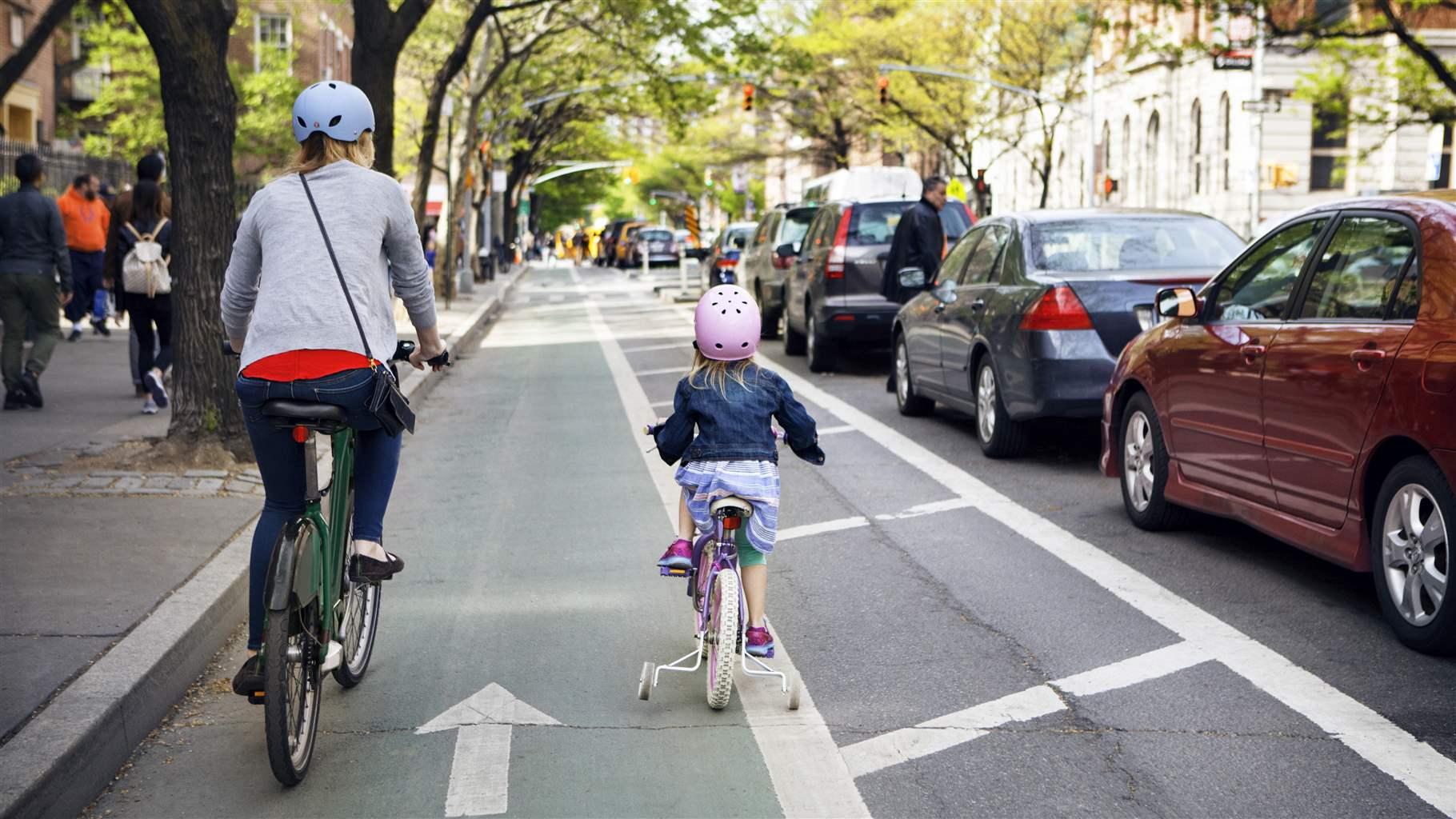 Mother and daughter riding bicycles in city