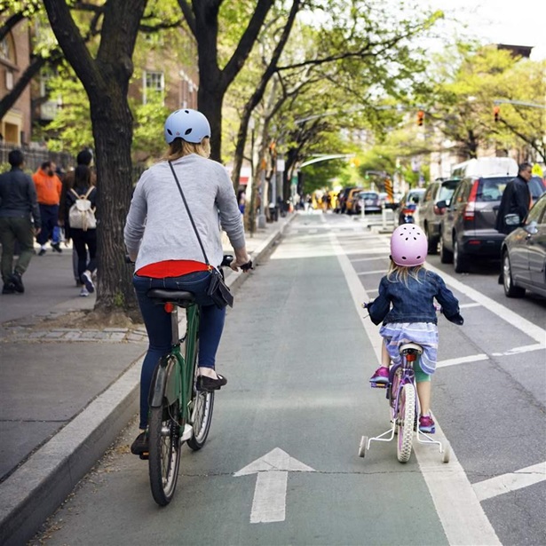 Mother and daughter riding bicycles in city