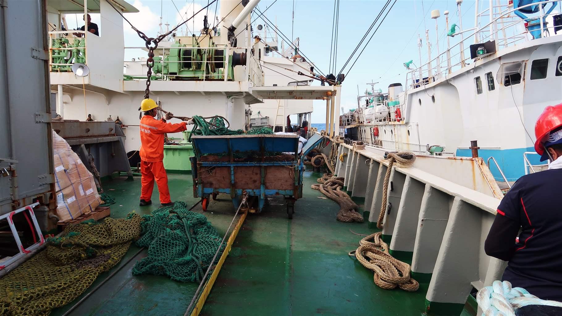 A man carrying shipment to a boat in the Pacific Ocean