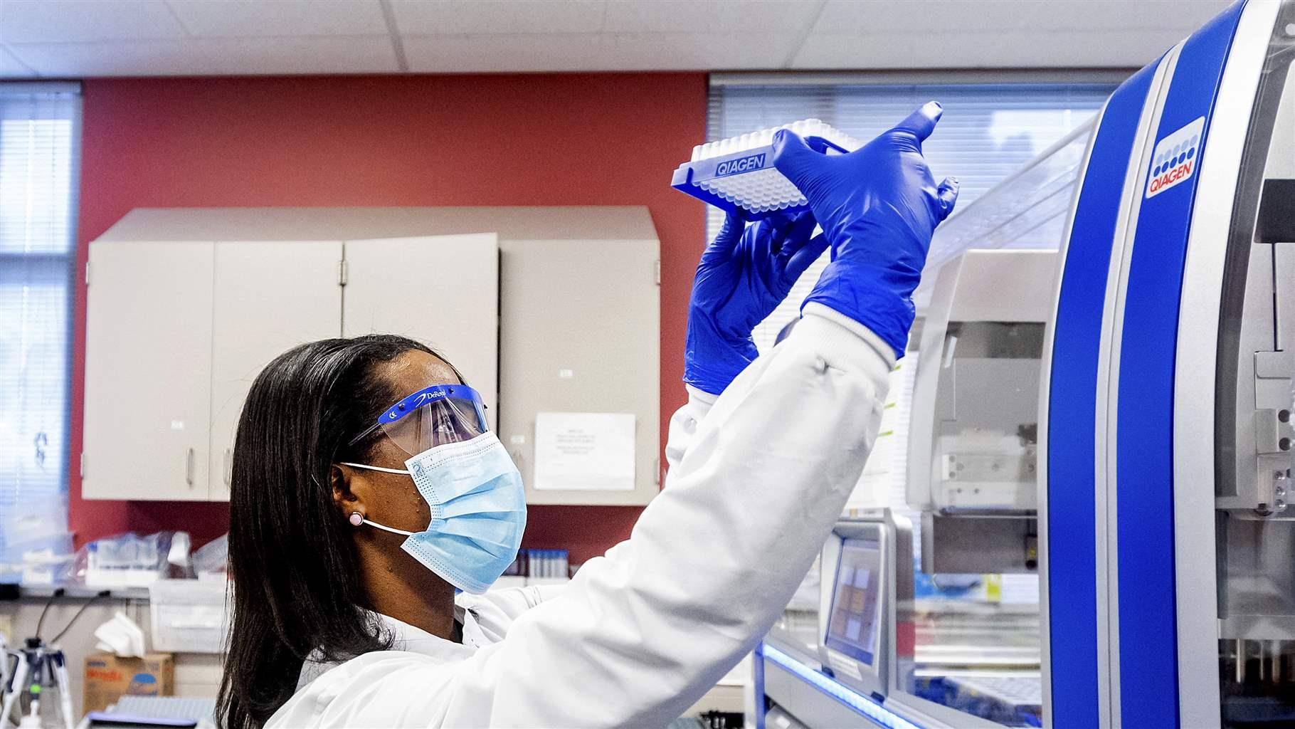 Clinical lab scientist Selam Bihon processes upper respiratory samples from patients suspected of having COVID-19 at the Stanford Clinical Virology Laboratory on Wednesday, Feb. 3, 2021, in Palo Alto, Calif.