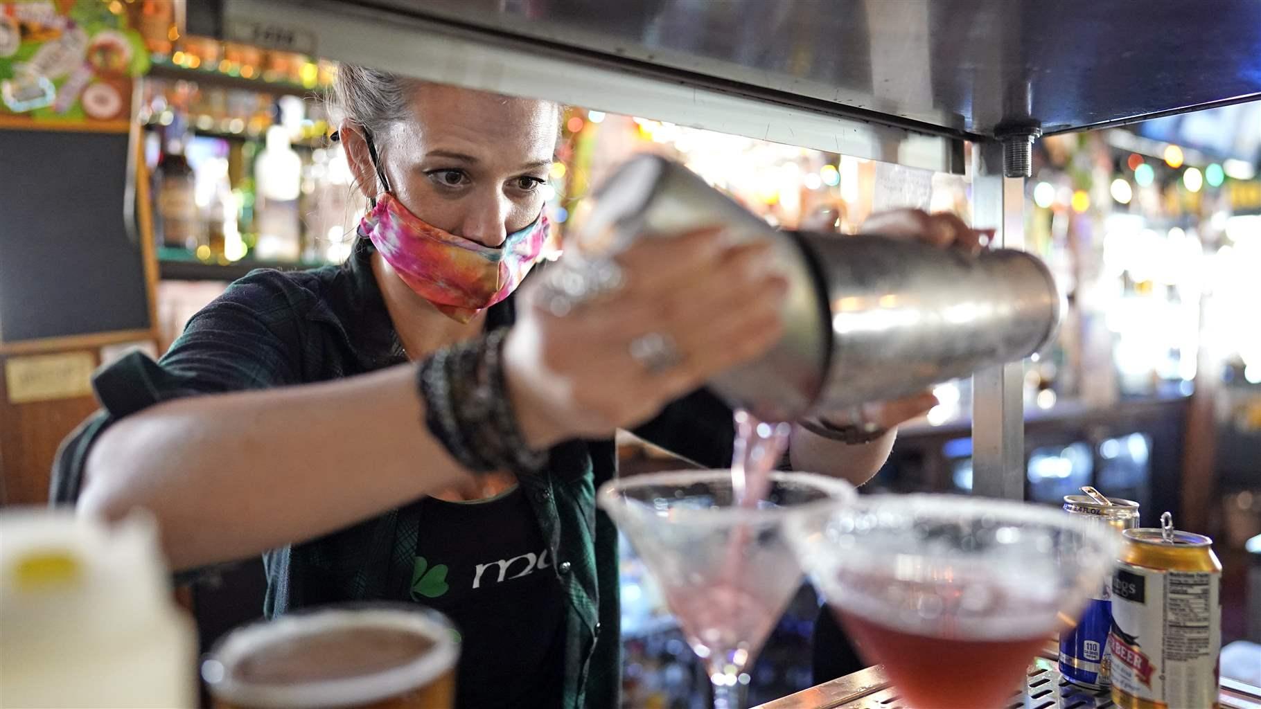 VIRUS OUTBREAK TEXAS Bartender Alyssa Dooley makes a cocktail at Mo's Irish Pub, Tuesday, March 2, 2021, in Houston. Texas Gov. Greg Abbott announced Tuesday that he is lifting business capacity limits and the state's mask mandate starting next week.