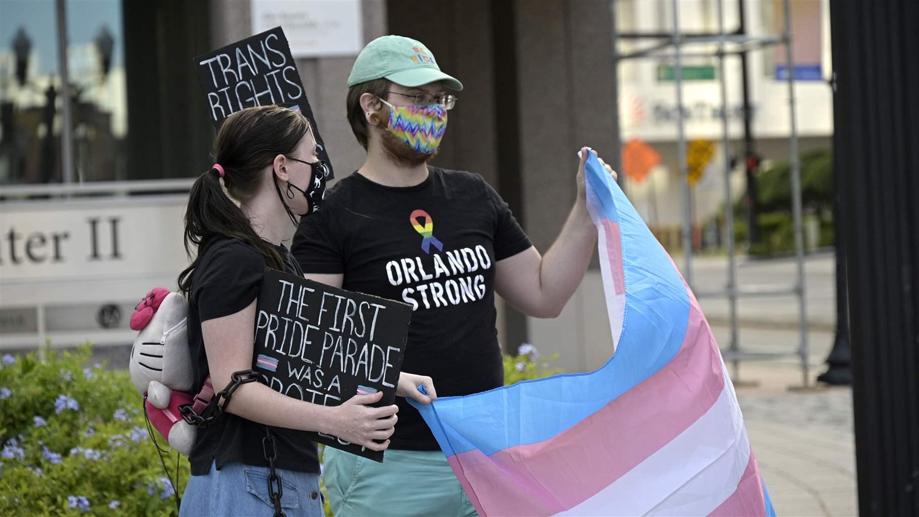 Activists attend a #ProtectTransKids rally outside Orlando City Hall after Gov. Ron DeSantis signed into law a ban on transgender girls from competing in girl's and women's sports during a new coronavirus pandemic, Tuesday, June 1, 2021, in Orlando, Fla