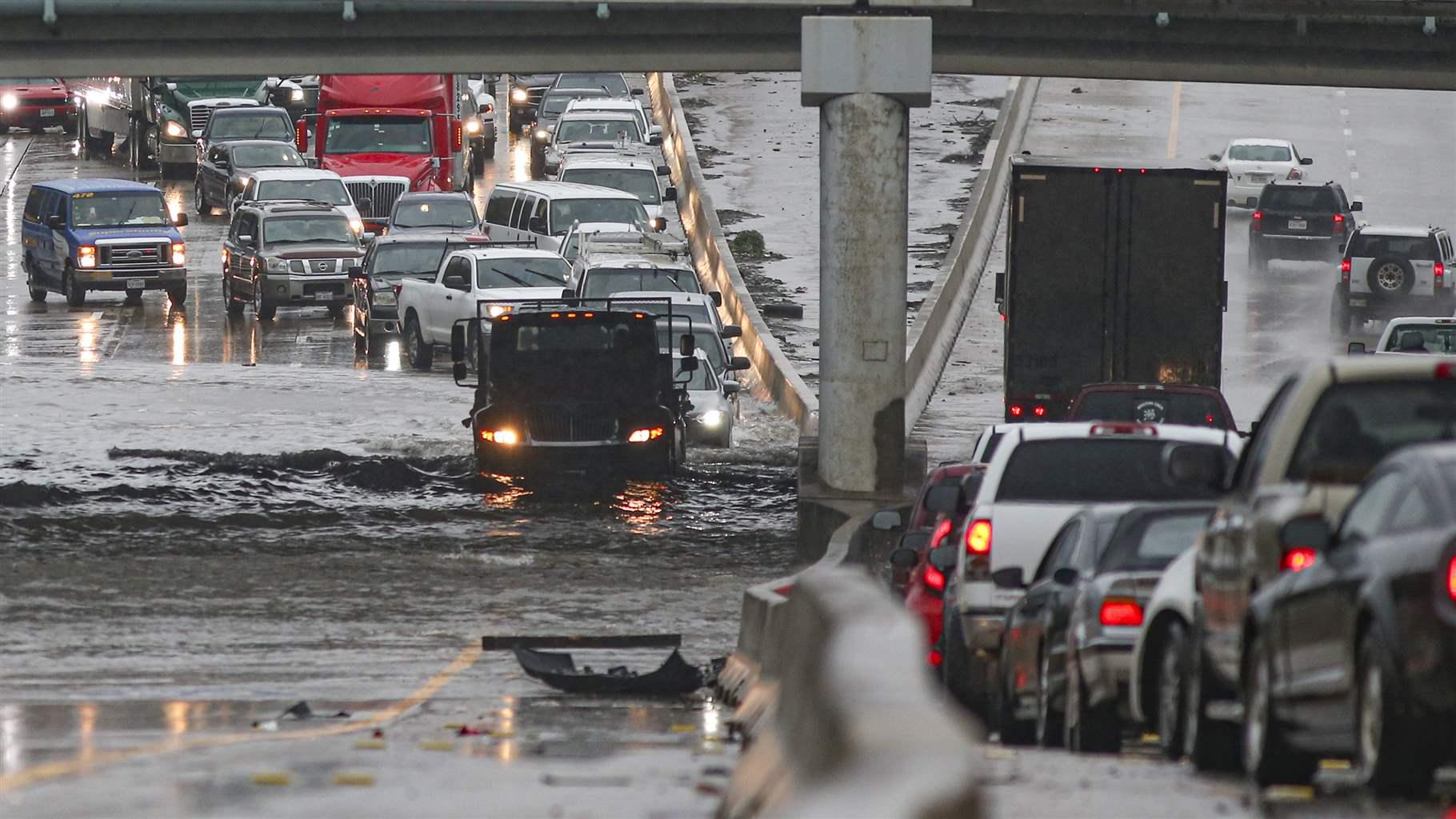 Cars pull to the side of the freeway of highway 69 North to get by the flood waters on September 19, 2019 in Houston, Texas.