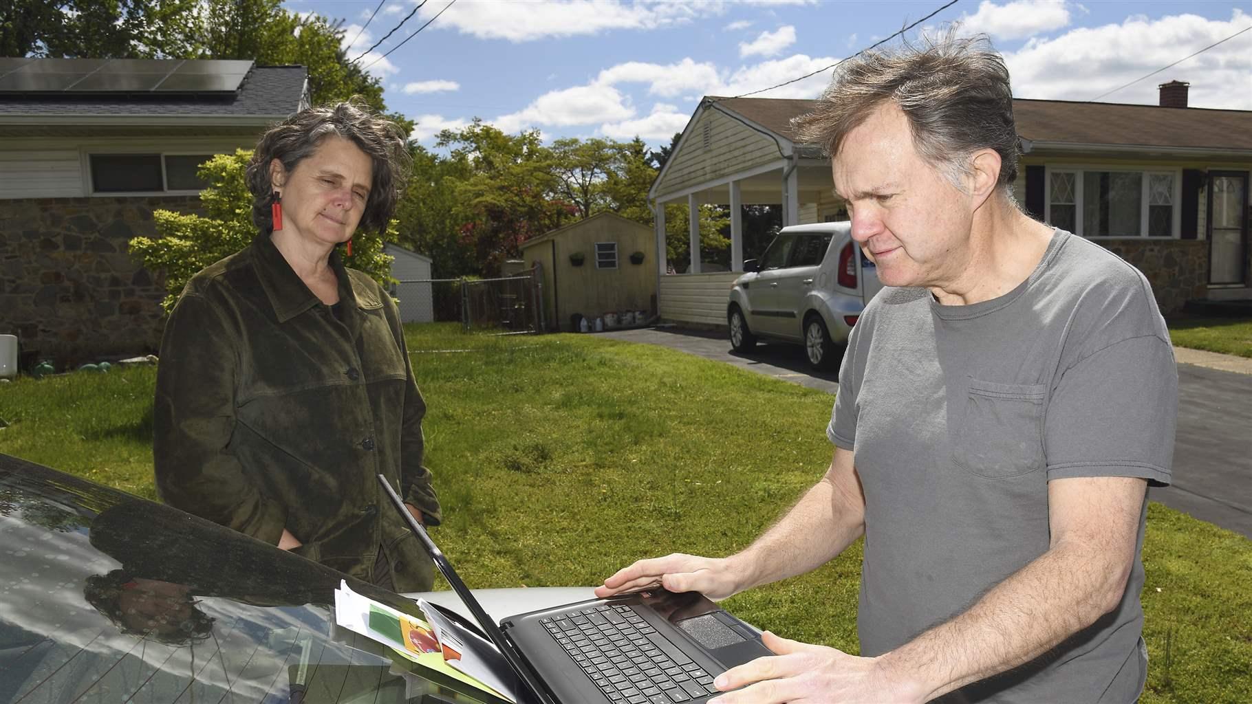 Ed Witles, right, who has been repairing and repurposing discarded or donated older computers and donating them to students, looks over a laptop in Glen Burnie, Maryland. 