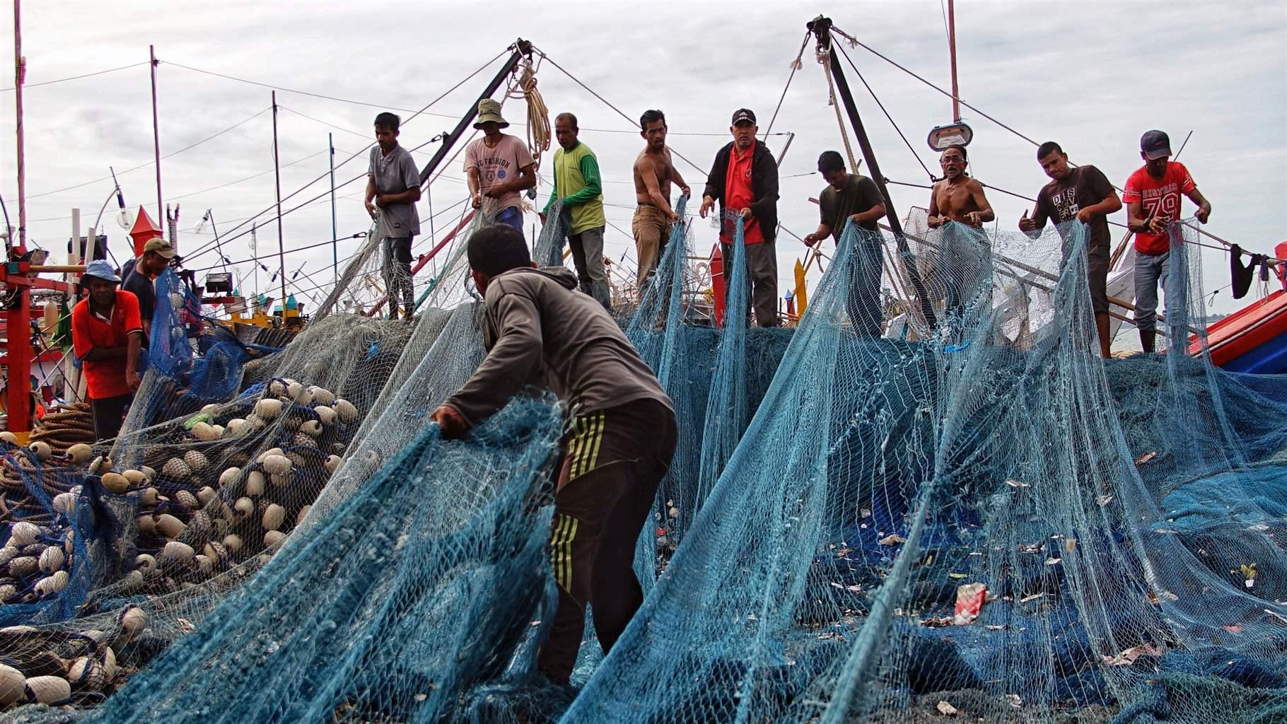 Fishermen at port prepare their vessel and gear for sea.