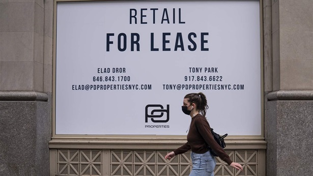 A woman walks past an empty commercial retail space April 28, 2021 in midtown New York City