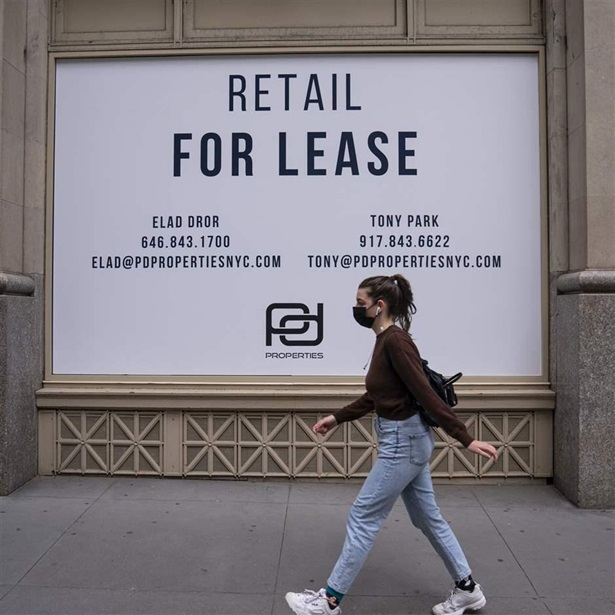 A woman walks past an empty commercial retail space April 28, 2021 in midtown New York City