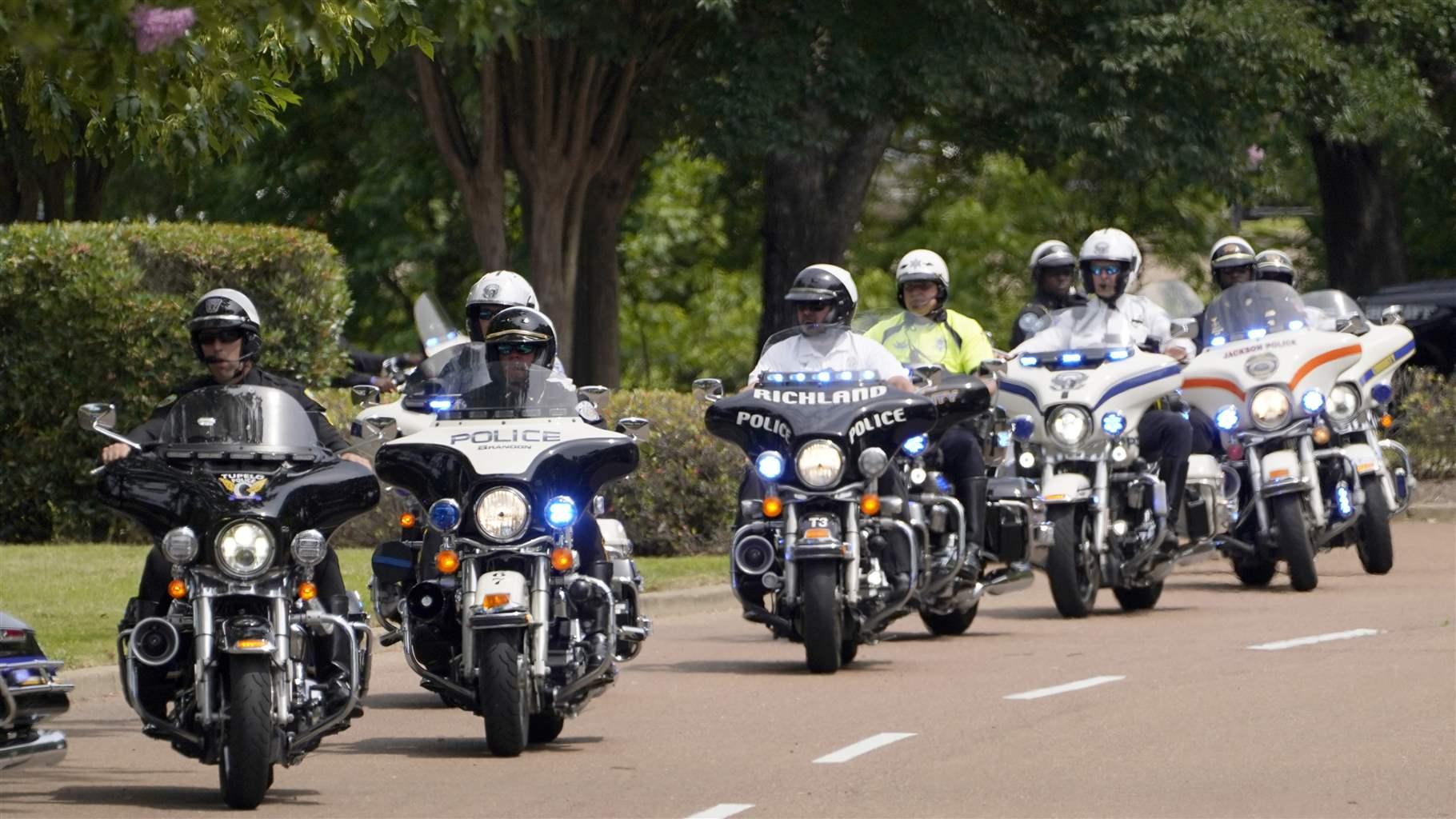 A motorcycle escort of lawmen from area agencies were among the motorcade led by members of the Mississippi Highway Patrol preceding the hearse bearing the body of Trooper John Harris, Tuesday, June 1, 2021, in Madison, Miss., as it is driven to Broadmoor Baptist Church for funeral services.