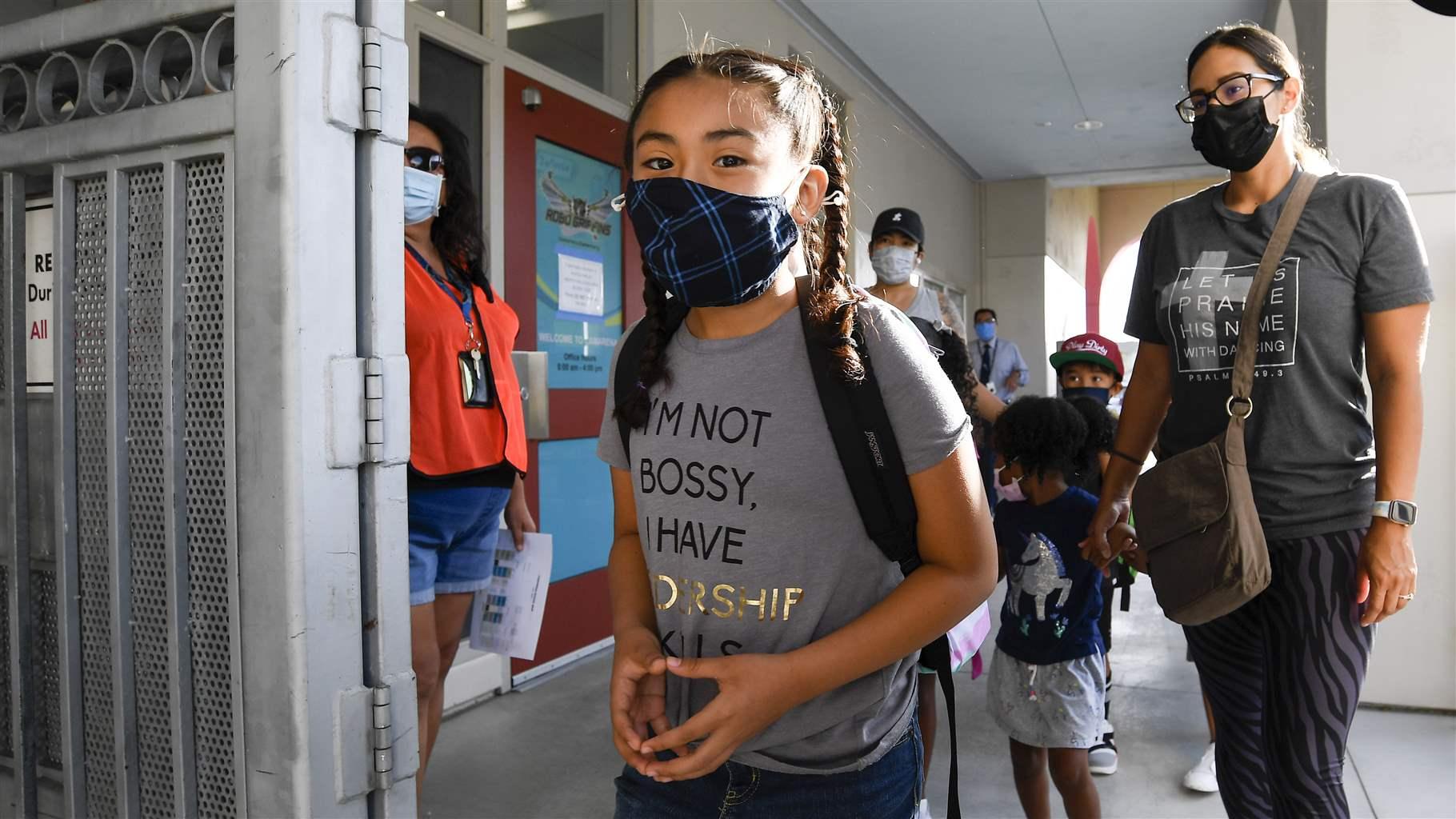 Students and parents walk into school on the first day of school at Enrique S. Camarena Elementary School Wednesday, July 21, 2021, in Chula Vista, Calif