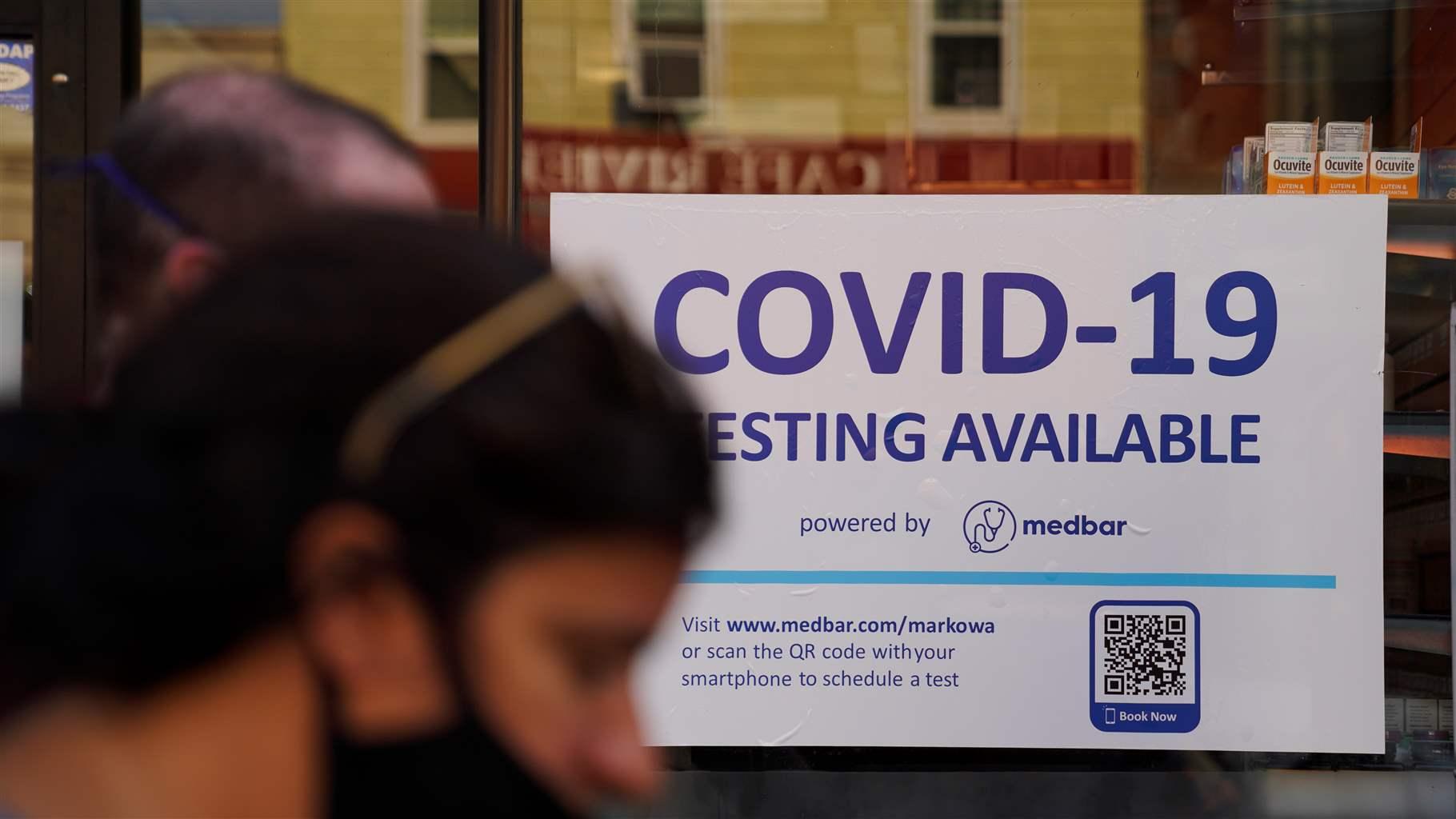 A pedestrian walks past a COVID-19 testing billboard in New York, the United States, July 26, 2021.