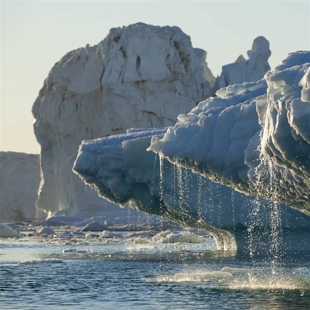 Massive icebergs from Jakobshavn Glacier melting in Disko Bay on sunny summer evening, Ilulissat, Greenland.