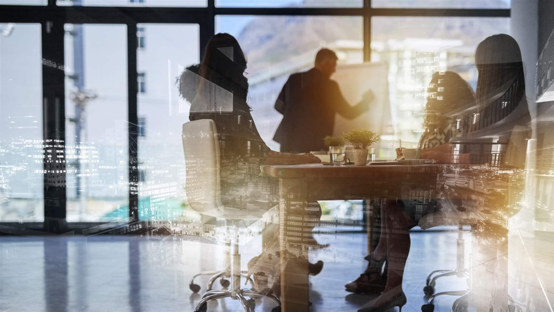 Description Shot of a team brainstorming, business people double exposed with an image of a city