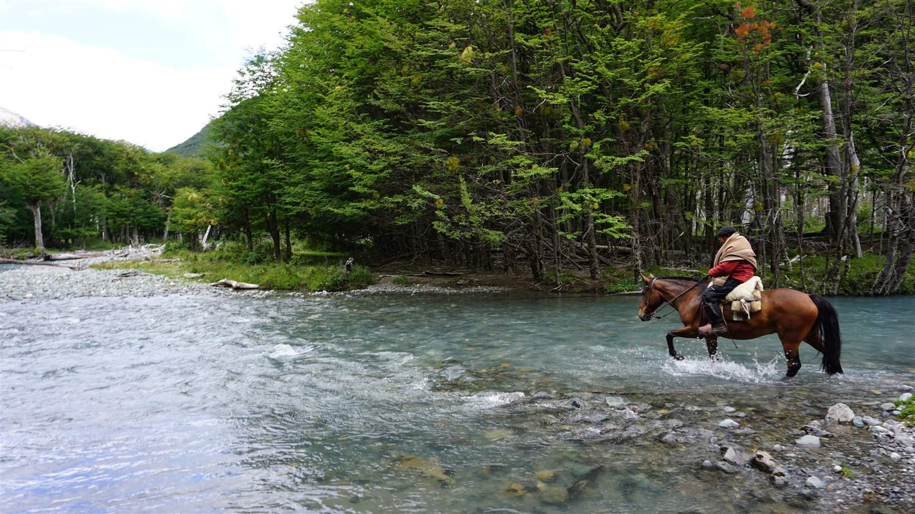 A tour guide crosses a river in Aysén, in the northern part of Chile’s Patagonia region—an area bursting with biodiversity and rich in local traditions.