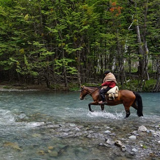 A tour guide crosses a river in Aysén, in the northern part of Chile’s Patagonia region—an area bursting with biodiversity and rich in local traditions.