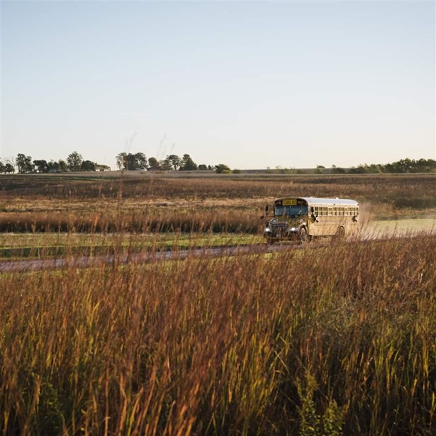 School bus traveling along dusty rural road, Missouri, USA