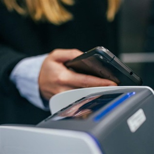 Hand holding phone scanning a payment system
