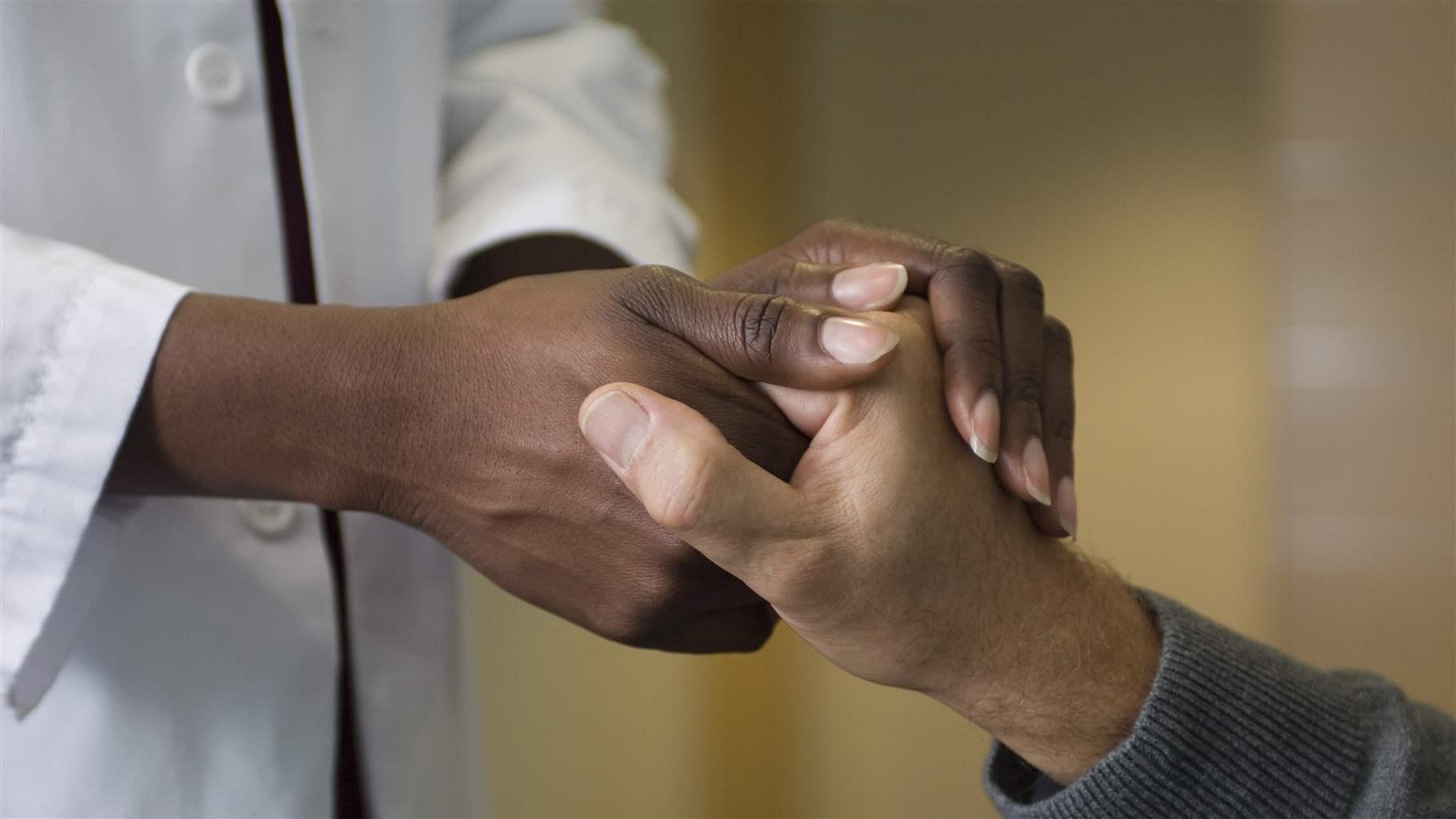 Doctor holding patient's hand