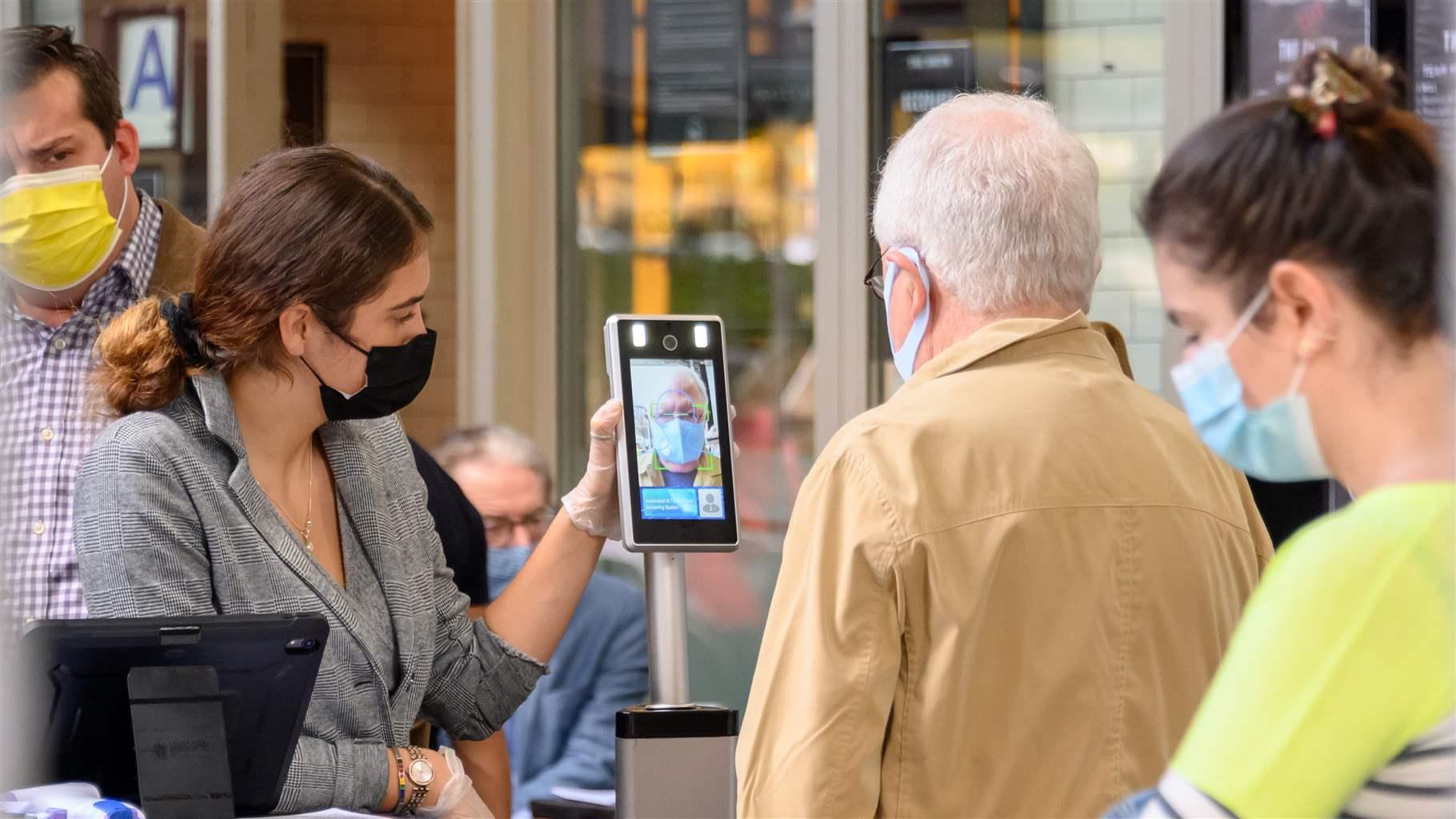 A person gets checked by an automated AI temperature screening system outside a restaurant on the Upper West Side as the city continues the re-opening efforts following restrictions imposed to slow the spread of coronavirus on November 10, 2020 in New York City.