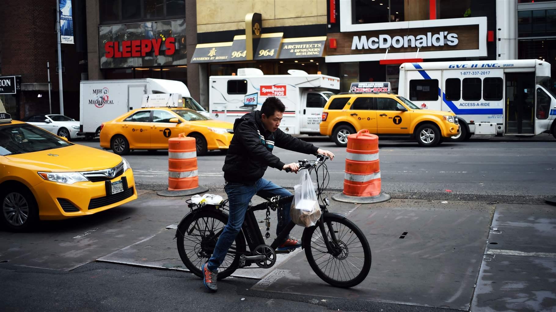 A food delivery man steers a bicyle along a street in New York on March 25, 2016.